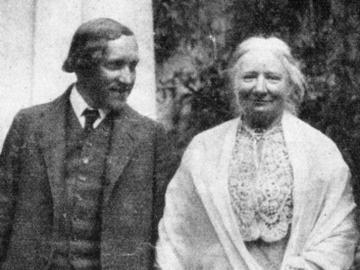 Schwarz weiß Foto von zwei Menschen, alt. Links ein Mann in einem Anzug und Krawatte, rechts eine Frau mit weißen Haaren und einem hellen umhängekleid